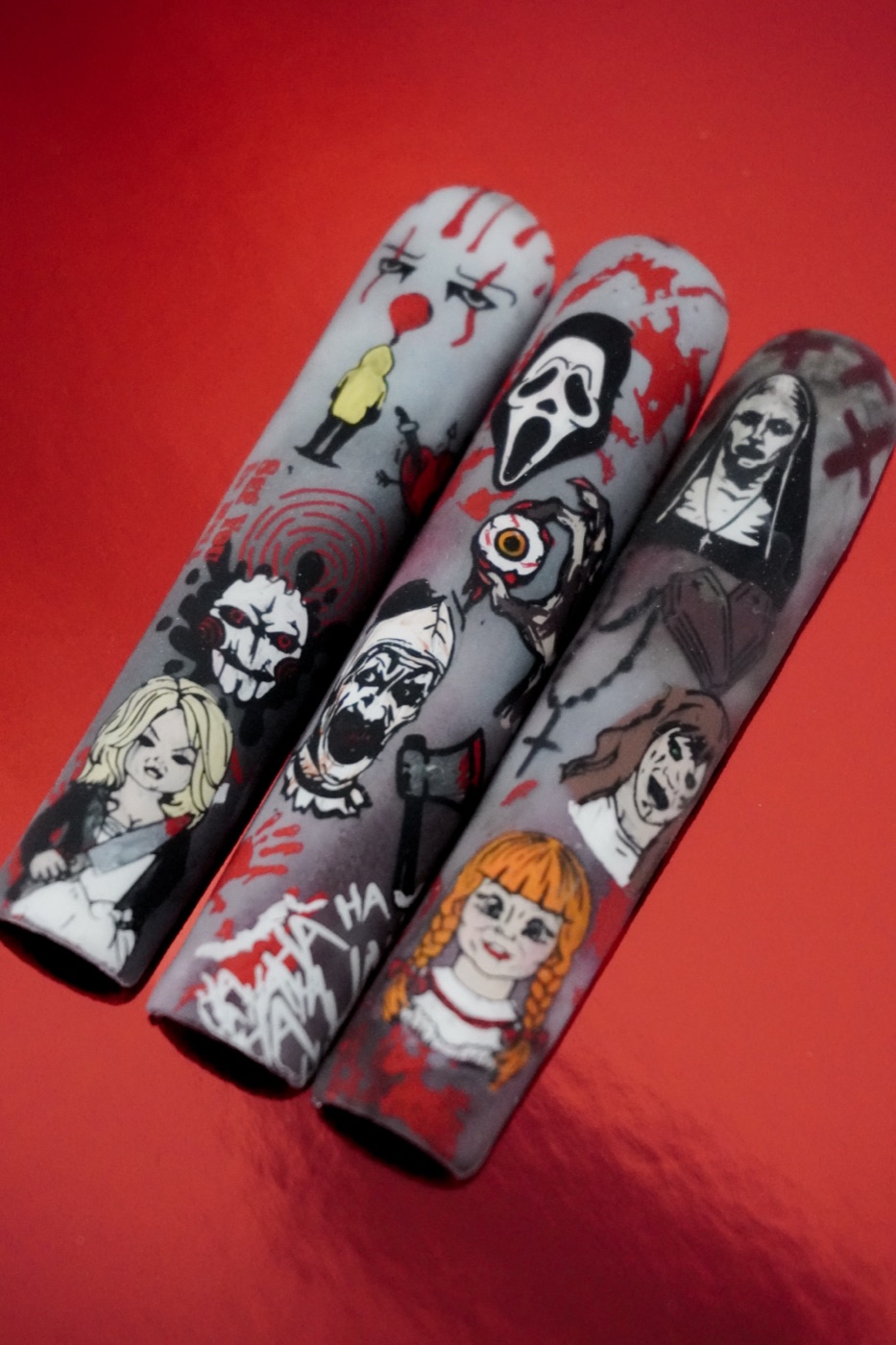 Uñas largas con nail art — personajes de terror pintados a mano